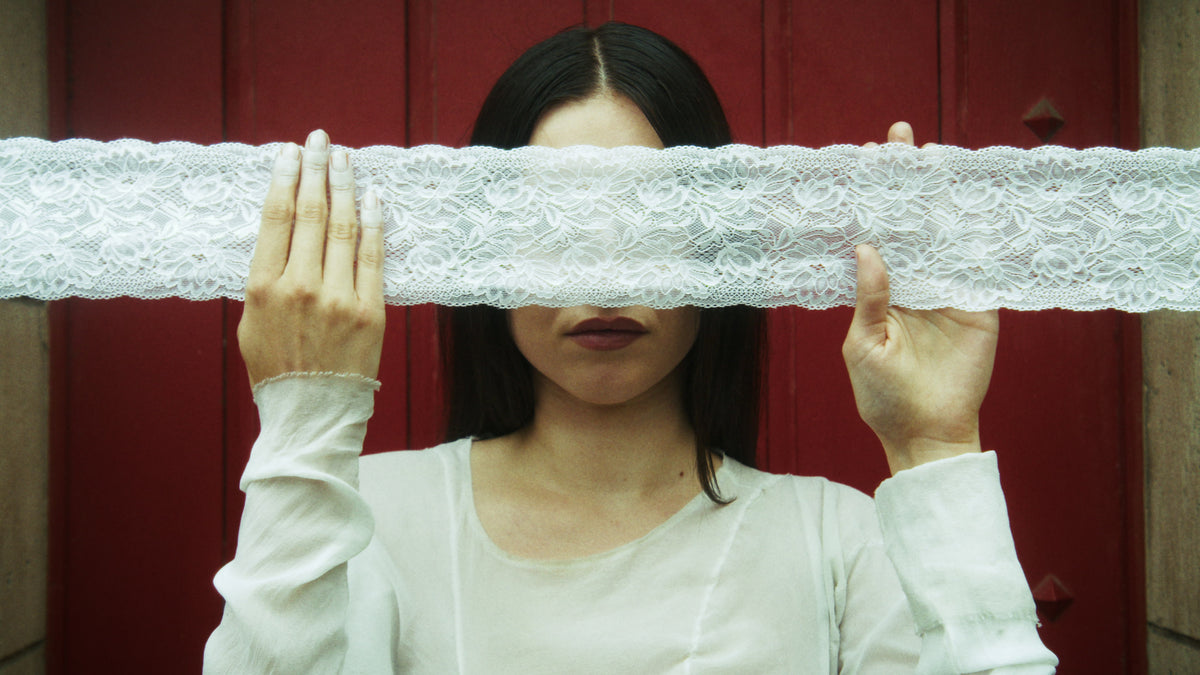 Adelina Bernard pre-campaign Like the Peeling of a Pomegranate woman holding white lace over her eyes