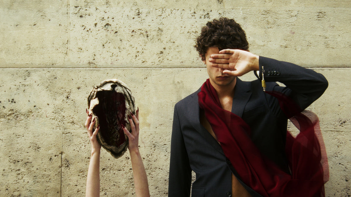 Adelina Bernard pre-campaign Like the Peeling of a Pomegranate man covering his eyes beside hollow skull sculpture