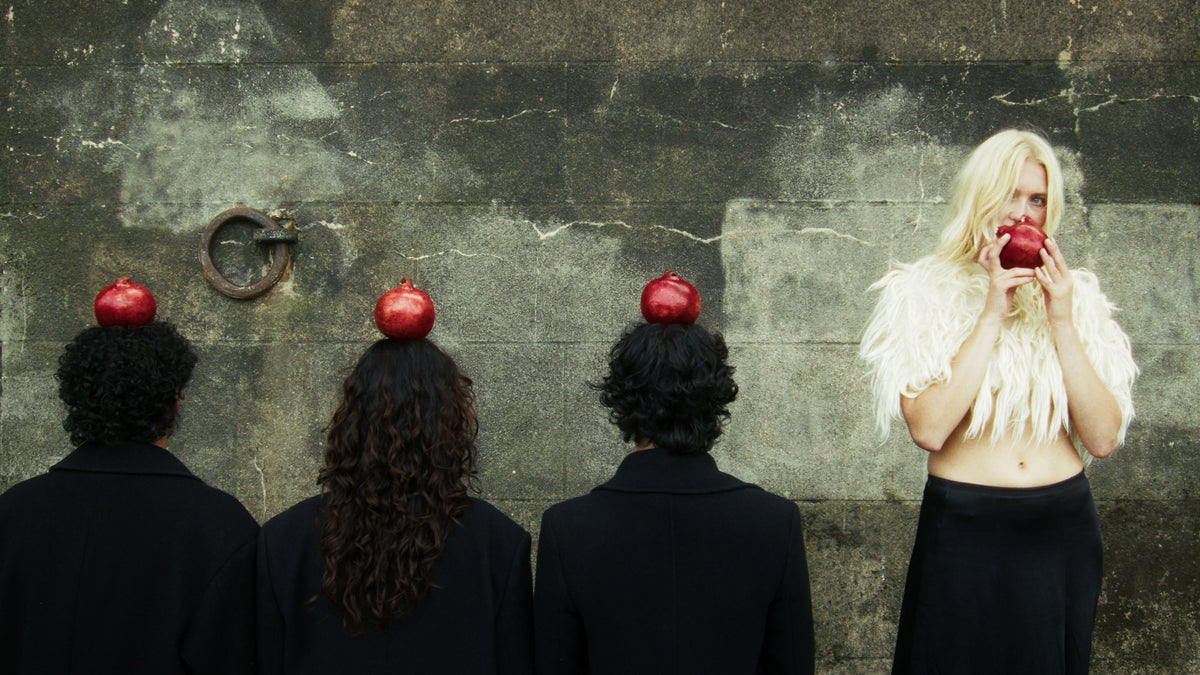 Adelina Bernard pre-campaign Like the Peeling of a Pomegranate figures with pomegranates on heads and woman eating pomegranate against stone wall