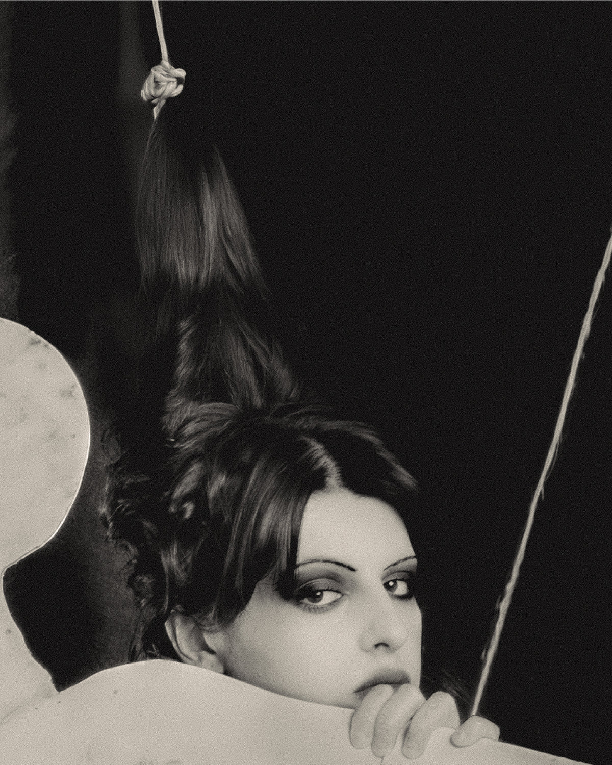 Adelina Bernard SS25 Pulling Strings campaign close-up Black and white portrait of a woman with hair hanging in puppet strings