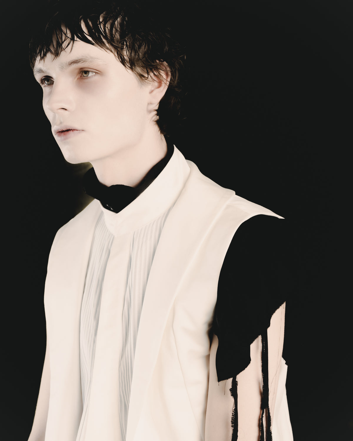 Adelina Bernard SS25 Pulling Strings campaign close-up of man wearing white layered vest with black top underneath