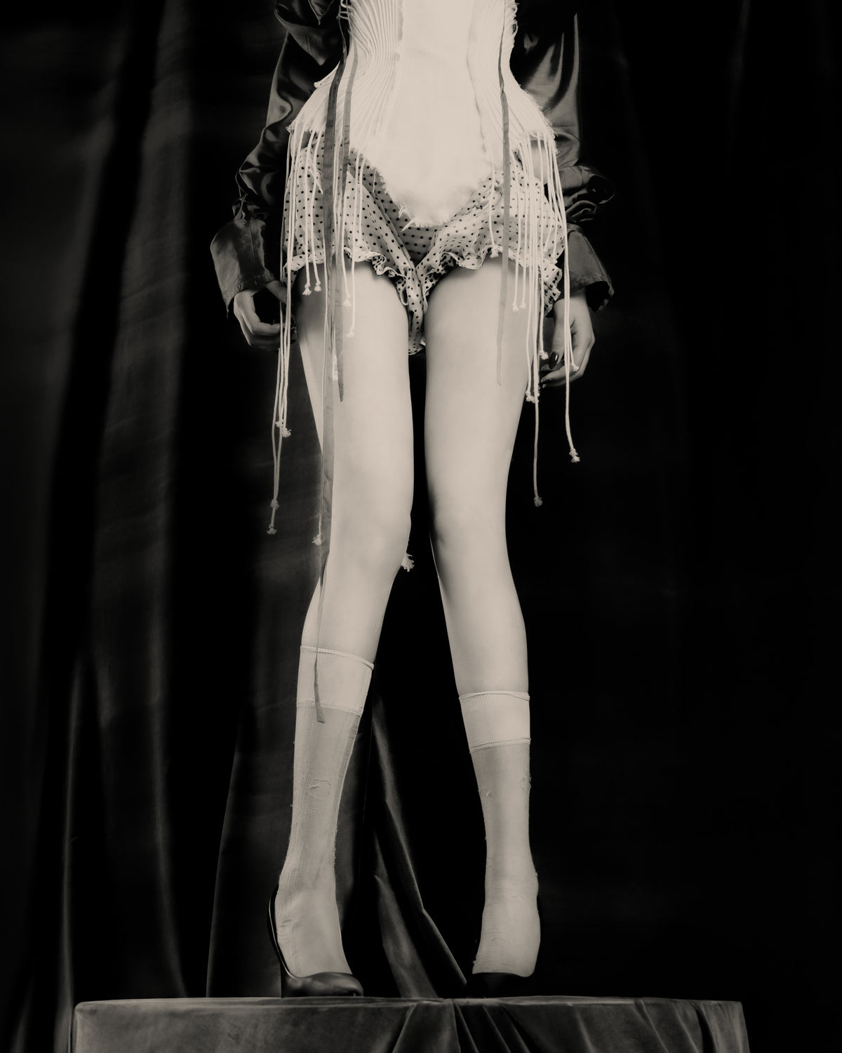 Adelina Bernard SS25 Pulling Strings campaign close-up of woman wearing corset with hanging strings and bloomers